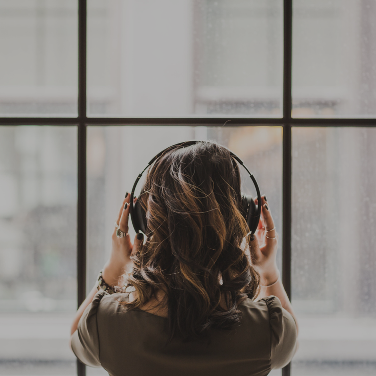 woman wearing headphones to indicate this section relates to romcom audiobooks